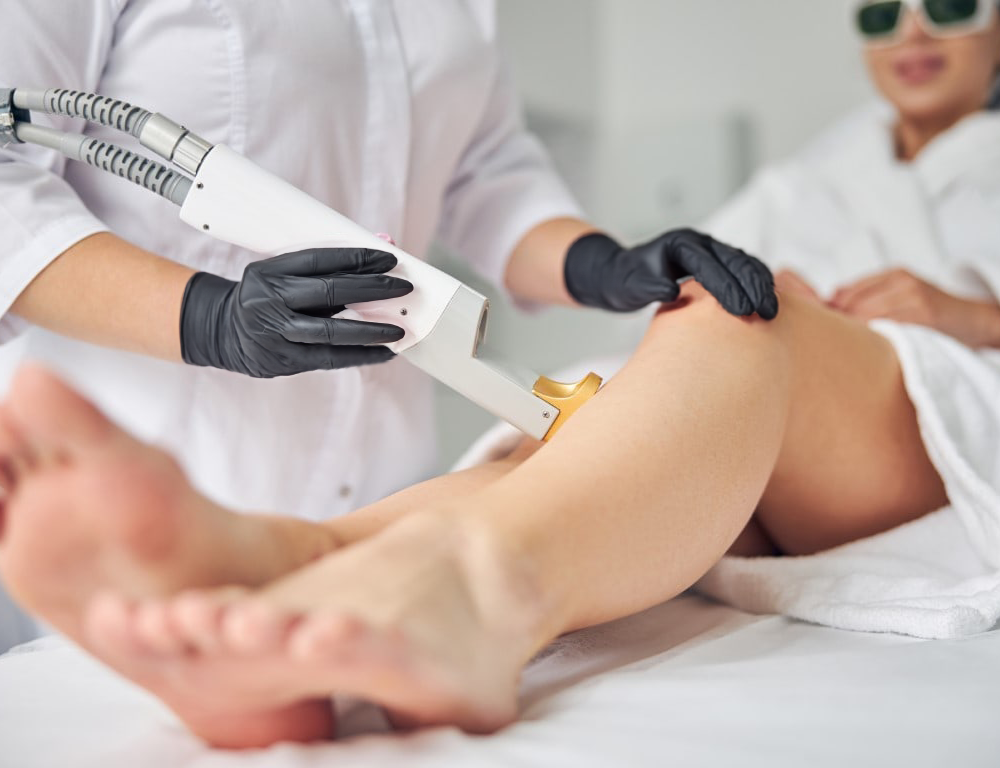 Das Foto zeigt wie eine Schulung mit einem Strahl an dem Bein einer Dame vorgeführt wird