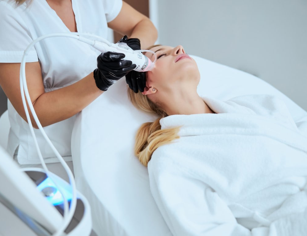 Dieses Foto zeigt eine Schulung für ein Frequenz Gerät, was bei einer Dame im Gesicht vorgeführt wird